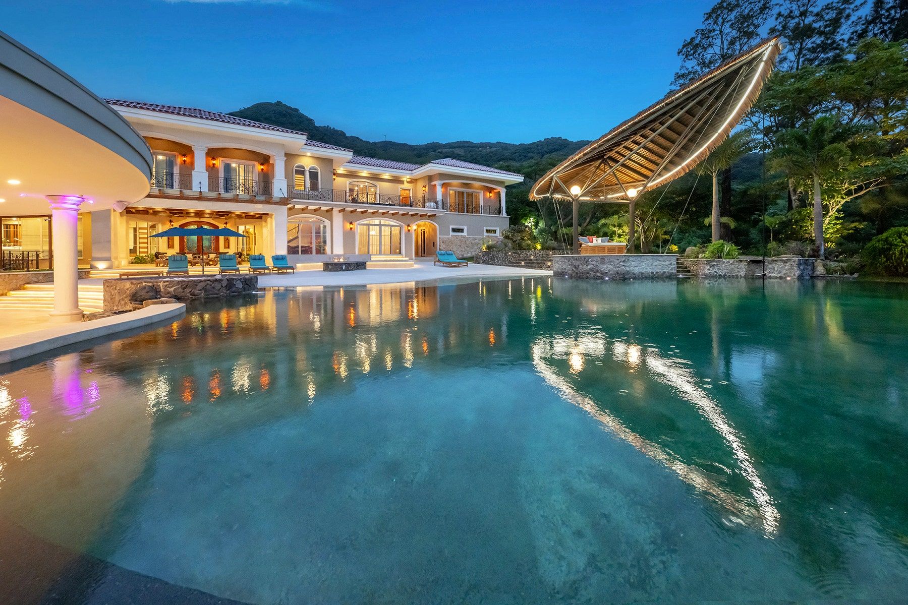 La Ponderosa at dusk: the saltwater pool, the main residence and the lit rancho